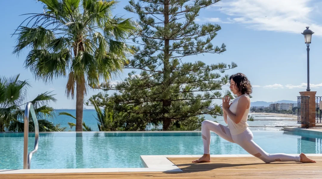 Femme pratiquant le yoga au bord de la piscine